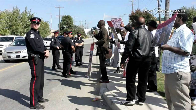 Des policiers de Toronto encadrent les manifestants lors de la visite de Paul Kagame le 23 septembre 2013.